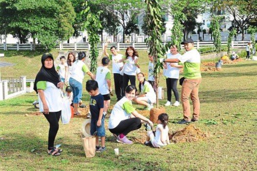 Residents and families posing with a tree they just planted for the programme. The particular tree will remain as part of each family’s responsibility and heritage in USJ Heights, inherited by future generations. / The Star
